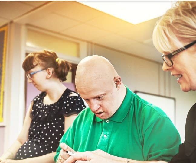 Three people working together on an activity in a bright, sunlit room